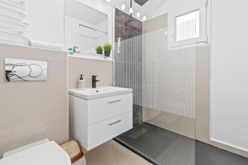 ein weißes Bad mit einem Waschbecken und einem WC in der Unterkunft Apartament Helena in Oradea