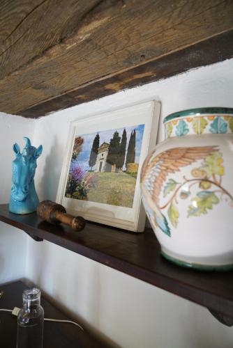 a shelf with a picture and a vase on it at Agriturismo La Colombella in Bagni San Filippo