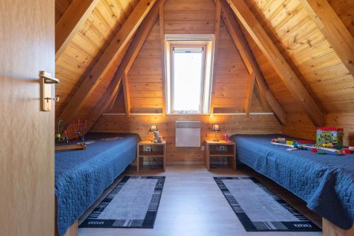 a attic room with blue beds and a window at HA 9 - Strandvogt 3 Komfort in Schottwarden