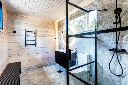 ein Bad mit einer Dusche und einer Glastür in der Unterkunft Saunamäki Resort - Seafront Luxury in Salo