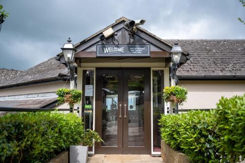 a welcome sign above the door of a building at Rising Sun Hotel by Greene King Inns in Cheltenham