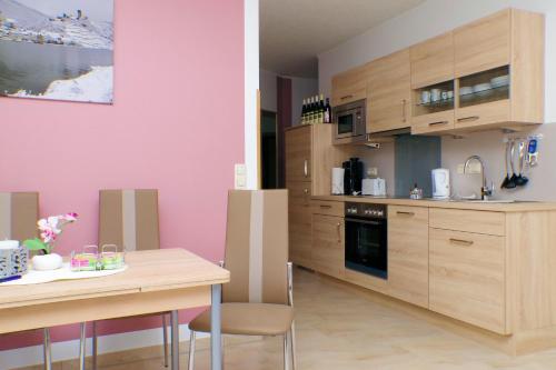 a kitchen with wooden cabinets and a table and a dining room at Beilsteiner Ferienwohnungen in Beilstein