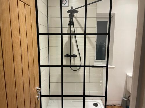 a shower in a bathroom with a glass wall at Nirvana house, 3 bedroom, 3 level riverside location in Deepcar