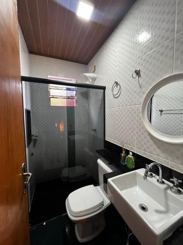 a bathroom with a sink and a toilet and a mirror at Cantinhos do Cipó - Chales privativos com hidro in Serra do Cipo