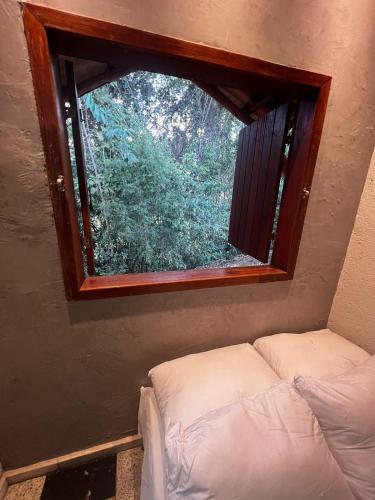 a small window in a room with a couch in it at Cantinhos do Cipó - Chales privativos com hidro in Serra do Cipo