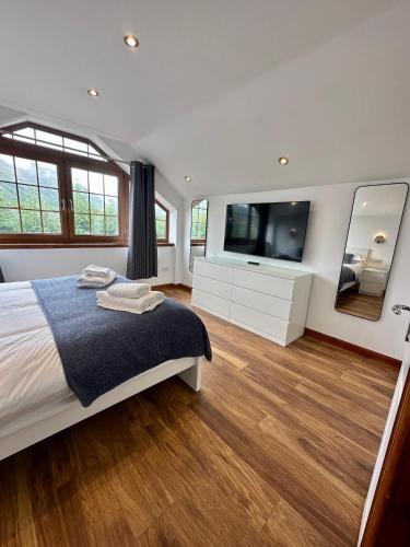 a bedroom with a bed and a flat screen tv at 2 Sheraton Apartments in Fort William