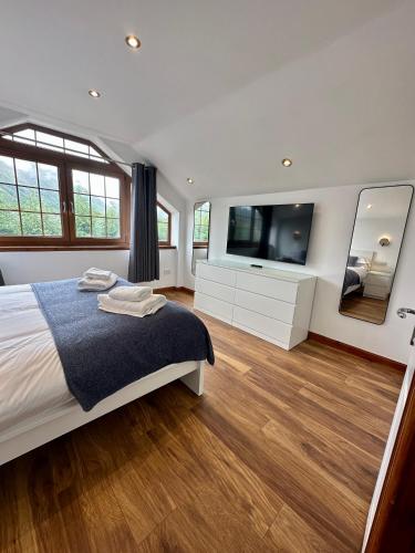 Un dormitorio con una cama y un televisor de pantalla plana. en 2 Sheraton Apartments, en Fort William