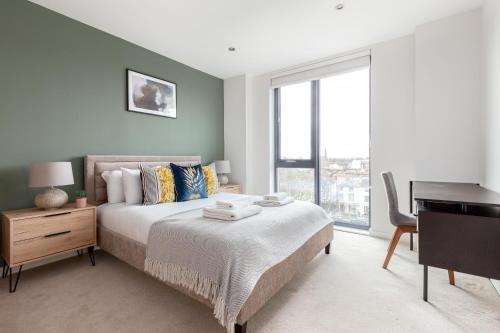 a bedroom with a bed with a desk and a desk at The Camden Apartment in London