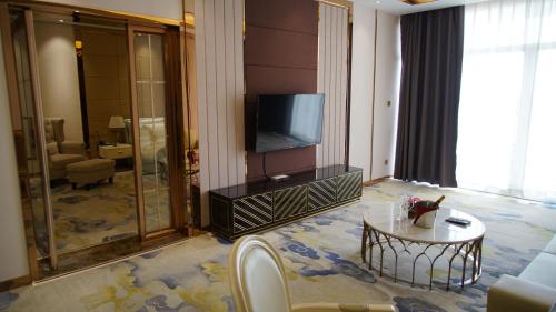 a living room with a television and a table at ST Hotel Wattay Airport in Vientiane