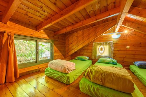 two beds in a room in a log cabin at Belfer's Dead Sea Cabins in Neʼot HaKikar