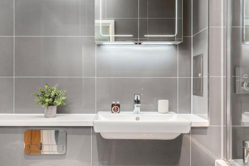a bathroom with a white sink and a mirror at The Camden Apartment in London