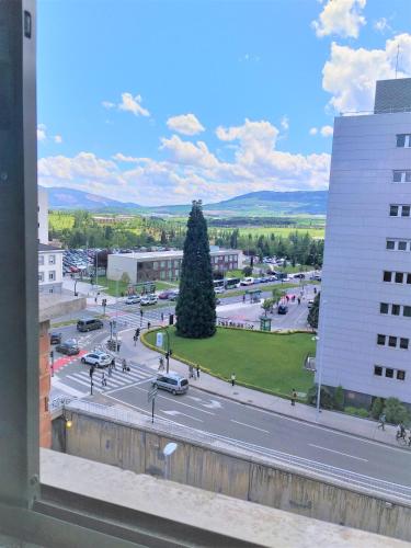 a view from a window of a street with a tree at Pensión Pamplonabeds in Pamplona