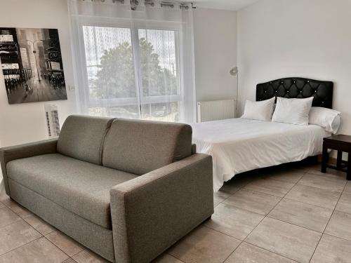 um quarto com uma cama, um sofá e uma cadeira em Residence 4T - 33 Avenue Gaston Chauvin em Aulnay-sous-Bois