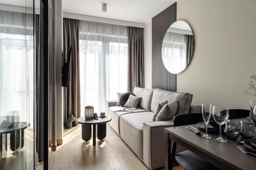 a living room with a couch and a table at Muse - LoftAffair Spa Collection in Kraków
