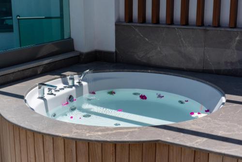 a bath tub with a sink in a room at Palm Hills Bodrum Hotel in Bodrum City
