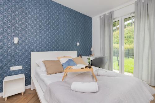 a bedroom with a bed with a table on it at Młyny Gdańskie Apartment with Terrace, Gym & Playground by Renters in Gdańsk