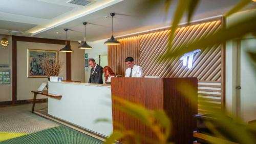 a group of people standing at a reception counter at Holiday Inn Ankara-Kavaklidere, an IHG Hotel in Ankara