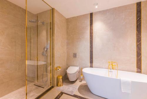 a bathroom with a tub and a shower and a toilet at Hilton Garden Inn Samarkand Sogd in Samarkand
