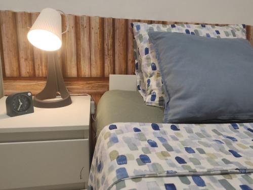 ein Schlafzimmer mit einem Bett und einer Lampe auf einem Nachttisch in der Unterkunft Casa Mari 