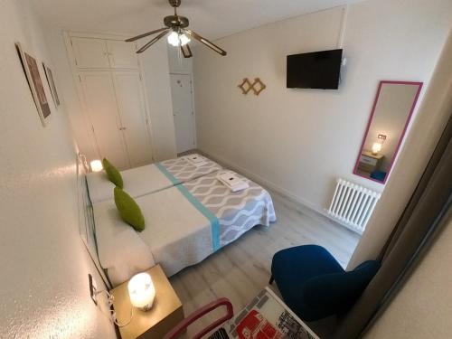1 dormitorio pequeño con 1 cama y 1 silla en Pensión Pamplonabeds en Pamplona