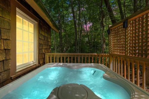a hot tub on the back of a house at Boozy Bear Bungalow romantic cabin 5 mins 2 downtown with hot tub and fire pit in Gatlinburg