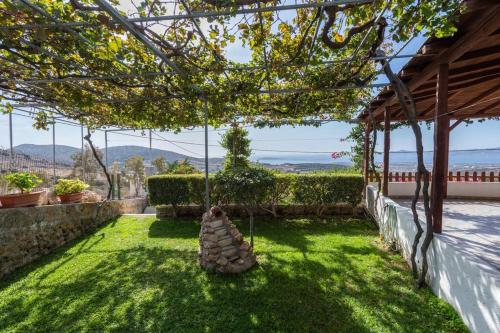 a garden with a hammock hanging from a roof at The Eagle's Nest house - overlooking Antiparos in Kamári
