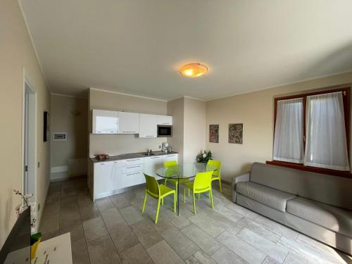 eine Küche und ein Esszimmer mit einem Tisch und gelben Stühlen in der Unterkunft Villa dei Roveri in Tignale