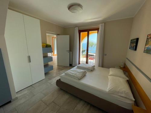 ein Schlafzimmer mit einem großen Bett und einem Fenster in der Unterkunft Villa dei Roveri in Tignale