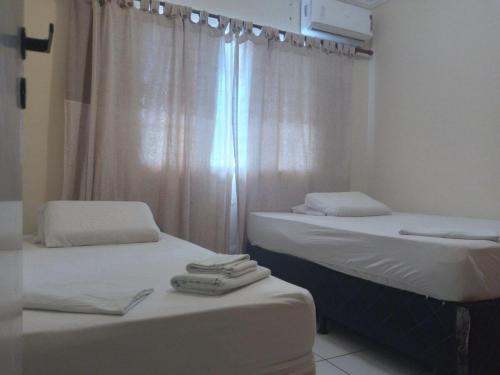 2 Einzelbetten in einem Zimmer mit Fenster in der Unterkunft ForTemporada - Seu Apto de frente para o mar em Fortaleza in Fortaleza