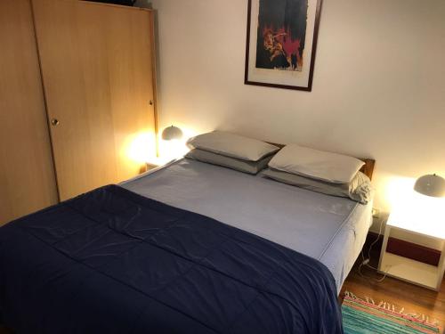 1 dormitorio con 1 cama con 2 almohadas en Monoambiente con baño privado y cocineta dentro de casa en Buenos Aires