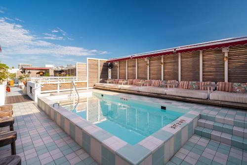 a swimming pool with lounge chairs next to a building at Esme Miami Beach in Miami Beach
