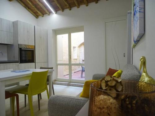 eine Küche mit einem Tisch und gelben Stühlen in einem Zimmer in der Unterkunft Casa Tecla alle Mura della Città in Siena