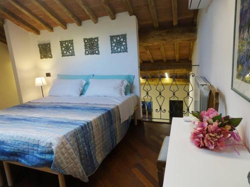 ein Schlafzimmer mit einem Bett und einem Tisch mit Blumen darauf in der Unterkunft Casa Tecla alle Mura della Città in Siena