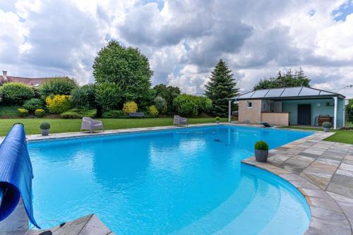 een groot blauw zwembad in een tuin bij Casa des Augas in Ousse