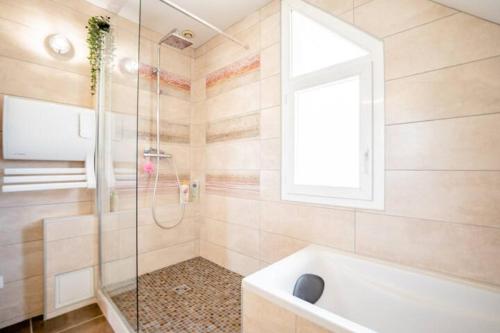 e bagno con doccia, vasca e finestra. di Casa des Augas a Ousse