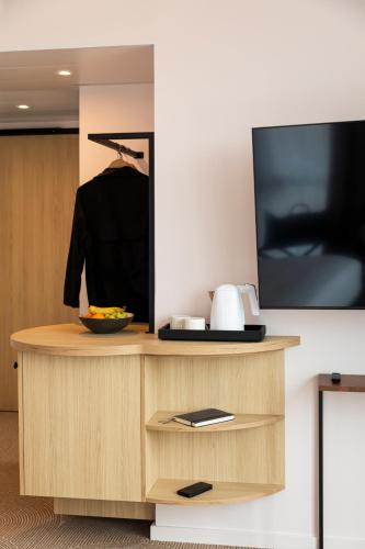 a desk with a tv and a bowl of food on it at Mercure Dunkerque Centre Gare in Dunkerque