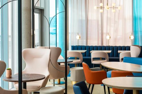 a restaurant with tables and chairs and windows at Mercure Dunkerque Centre Gare in Dunkerque