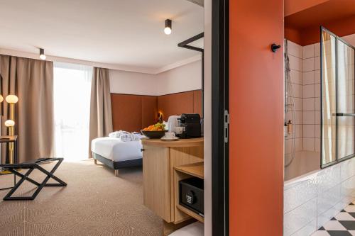 a hotel room with a bed and a bathroom at Mercure Dunkerque Centre Gare in Dunkerque