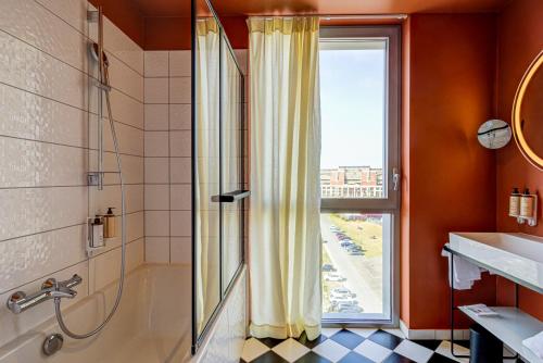 bagno con doccia, lavandino e finestra di Mercure Dunkerque Centre Gare a Dunkerque