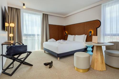 a hotel room with a bed and a table and a chair at Mercure Dunkerque Centre Gare in Dunkerque