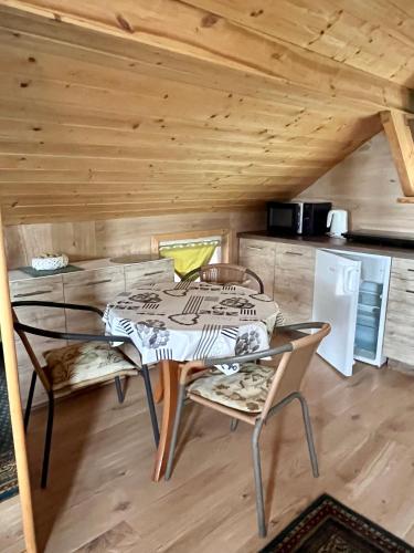a dining room with a table and chairs in a cabin at Apartamenty nad Zalewem Szczecińskim in Zagórze