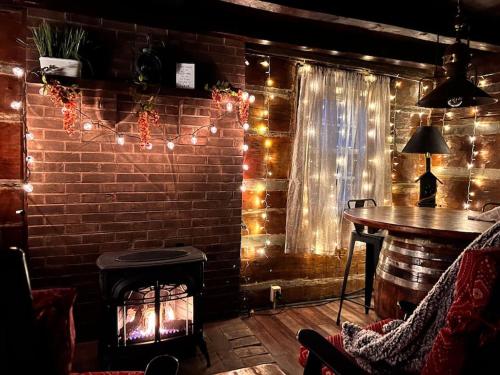 a room with a brick wall with a fireplace and a table at Boozy Bear Bungalow romantic cabin 5 mins 2 downtown with hot tub and fire pit in Gatlinburg