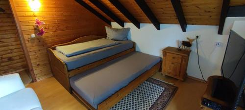 Habitación pequeña con cama y pared de madera. en Ferienwohnung Gläser en Hilchenbach