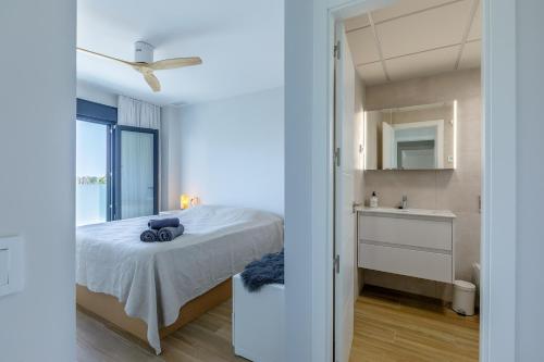a bedroom with a bed and a sink and a mirror at A&N Sea View Apartment with Pool & Parking Torre del Mar in Torre del Mar
