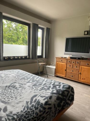 1 dormitorio con 1 cama y TV de pantalla plana en Homestay La Montagne des Coeurs, en Eigenbilzen