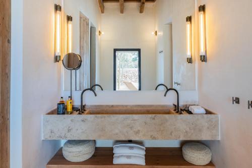 uma casa de banho com um lavatório de pedra e um espelho. em Vestige Son Vell em Ciutadella