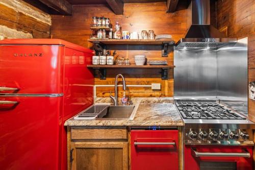 a kitchen with a red refrigerator and a sink at Boozy Bear Bungalow romantic cabin 5 mins 2 downtown with hot tub and fire pit in Gatlinburg