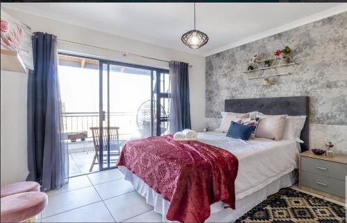 a bedroom with a large bed and a balcony at Vacation at the Blyde Riverwalk Estate in Pretoria