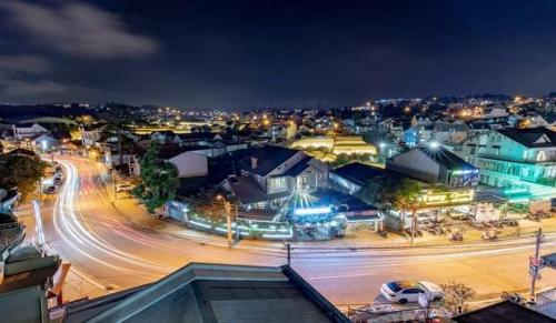 een stad 's nachts met auto's op straat bij Pema House Hotel in Da Thanh