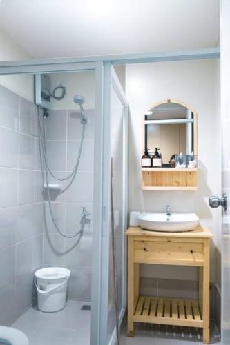 a bathroom with a shower and a sink and a toilet at Spacious and Cozy 1-Bedroom Condo at Brenthill in Baguio